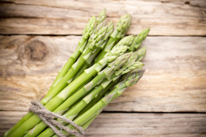 Asparagus on the wooden background.